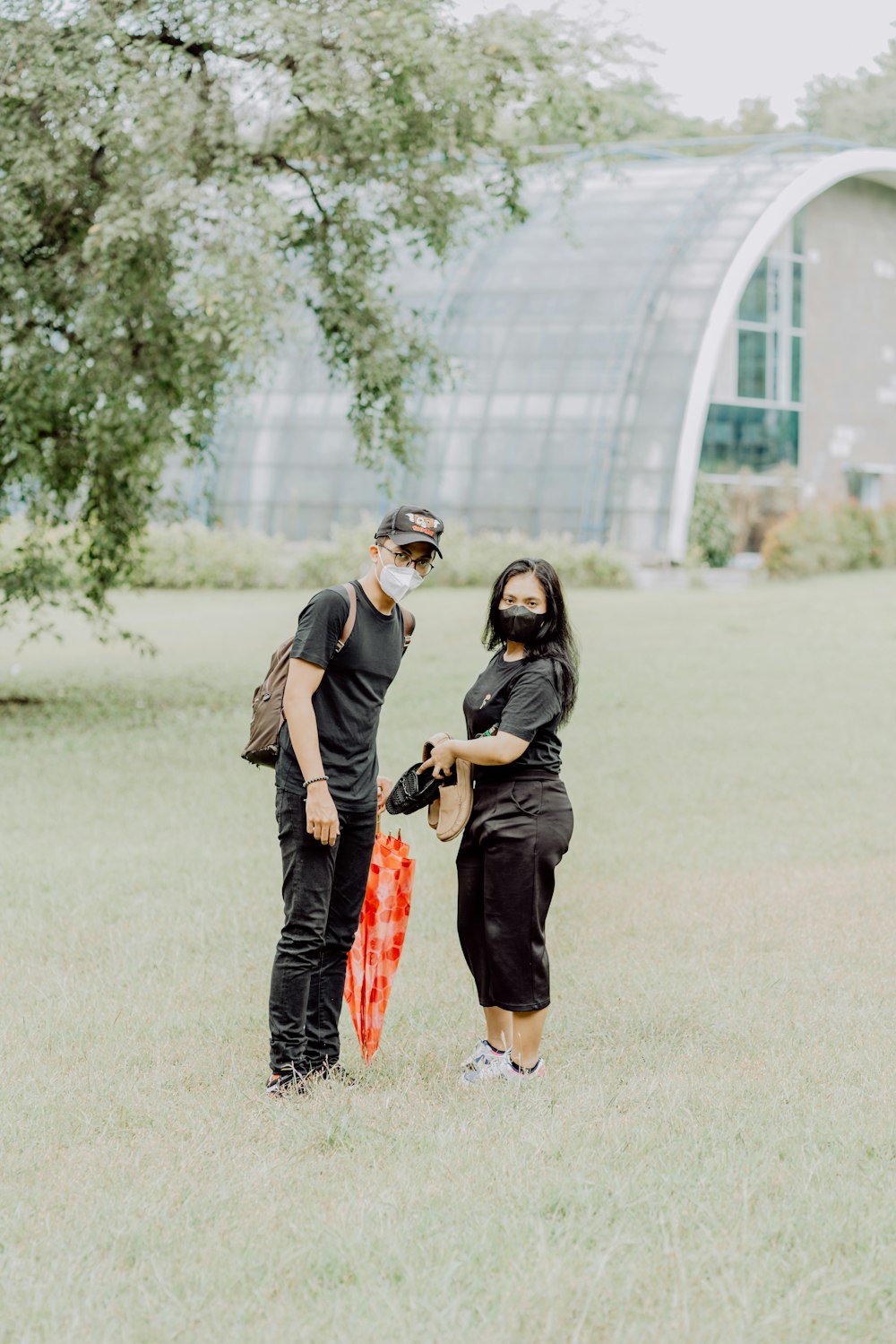 man and woman standing on green grass field during daytime