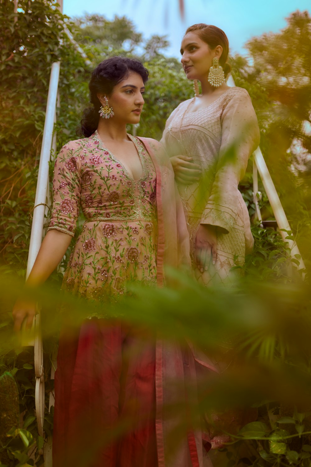 woman in red and brown floral dress standing on green grass during daytime