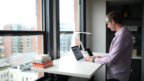 man in purple dress shirt using macbook pro