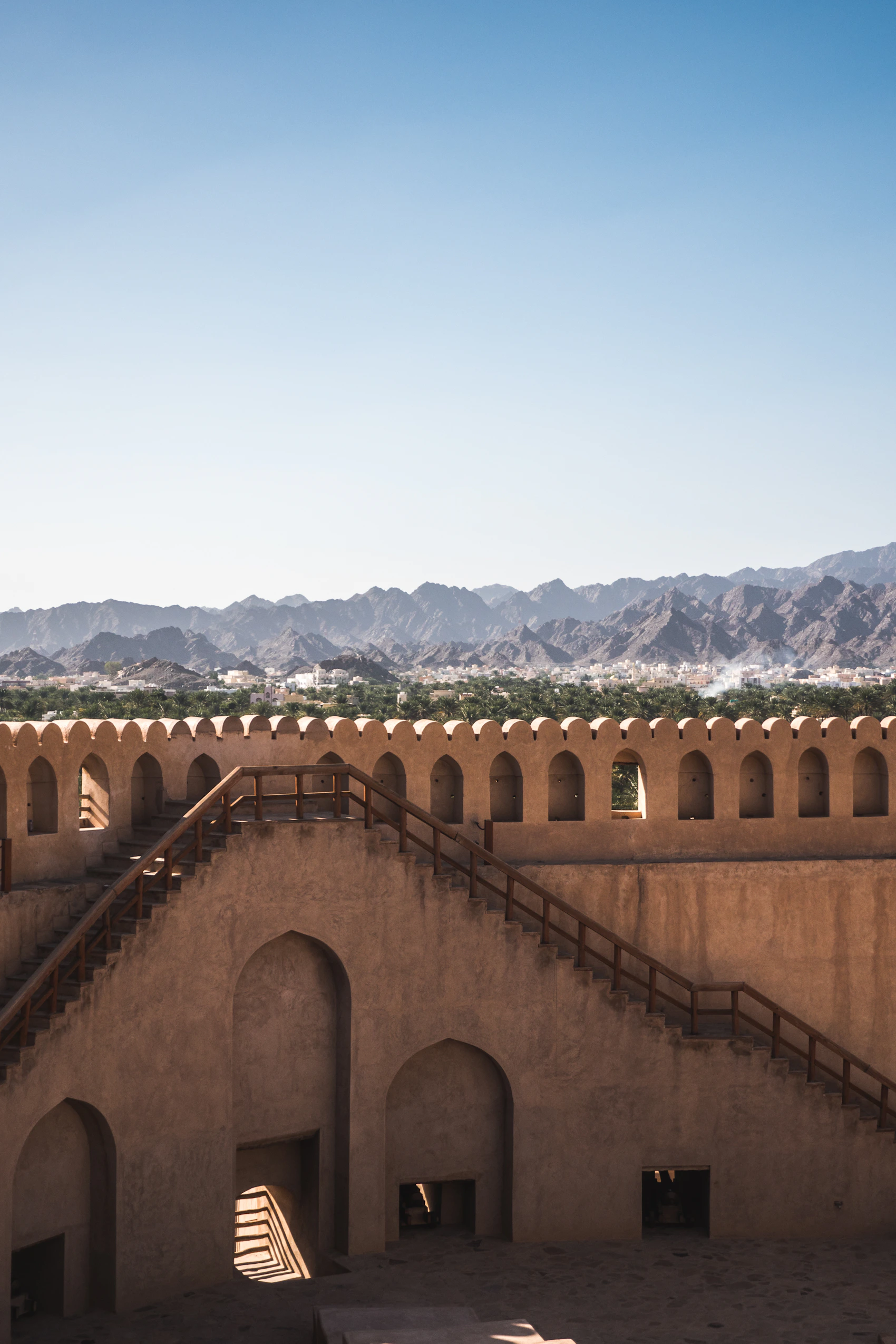 Nizwa Fort overlooking an oasis and the Hajar Mountains in Oman