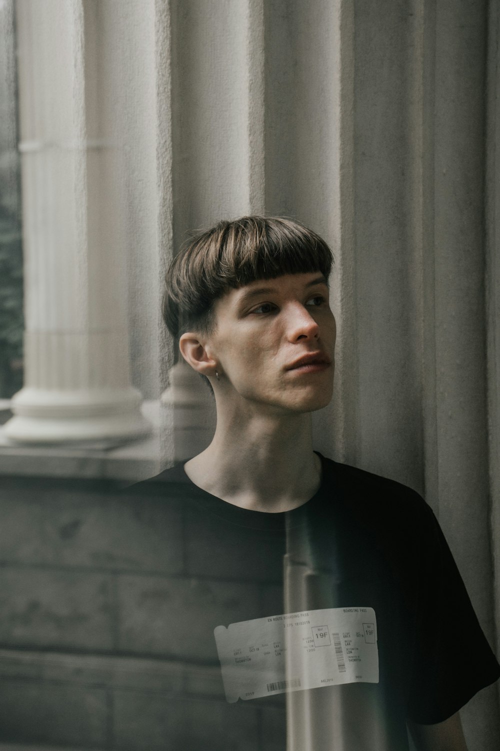 man in black crew neck shirt standing near window