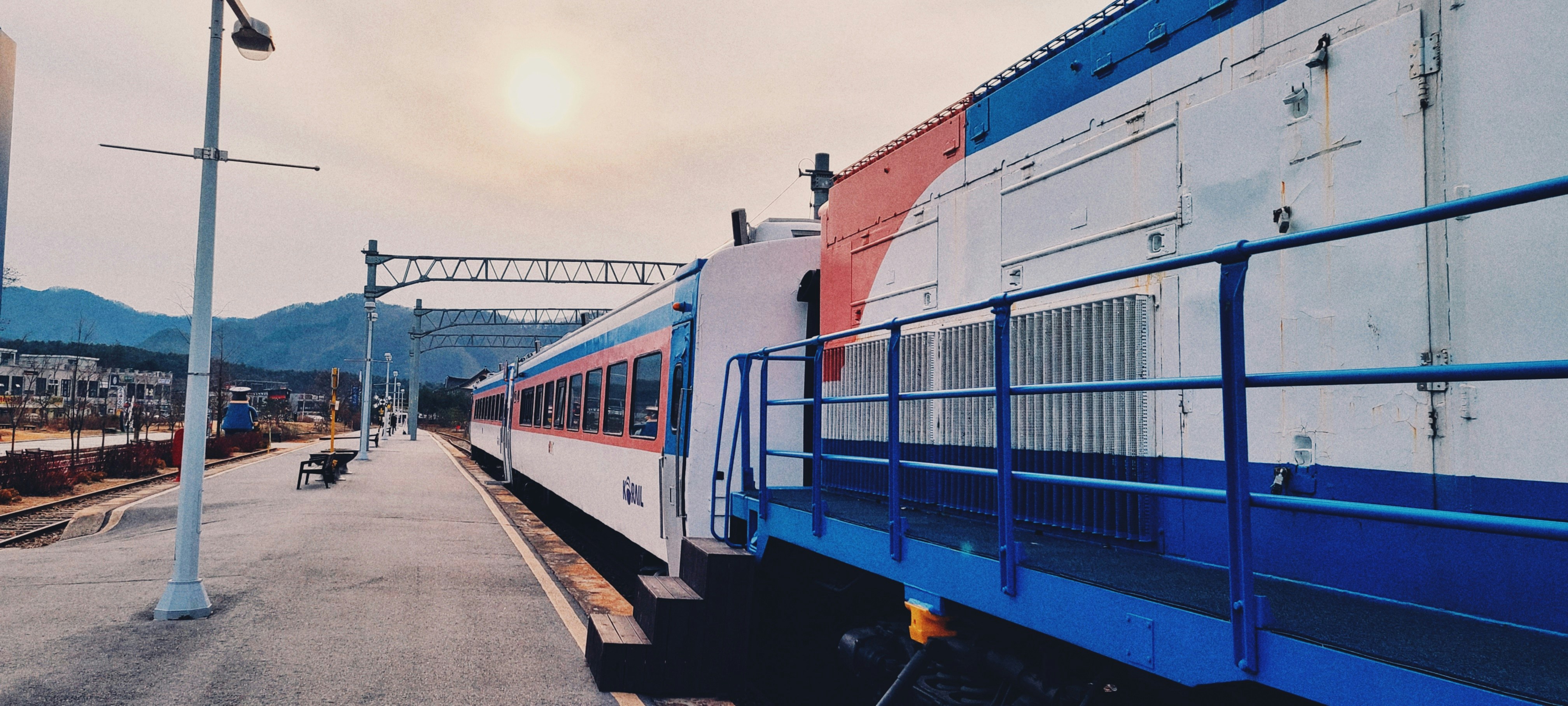 blue and red train on rail road during daytime