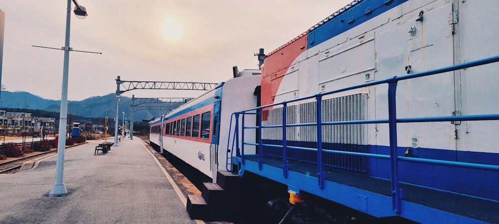 blue and red train on rail road during daytime