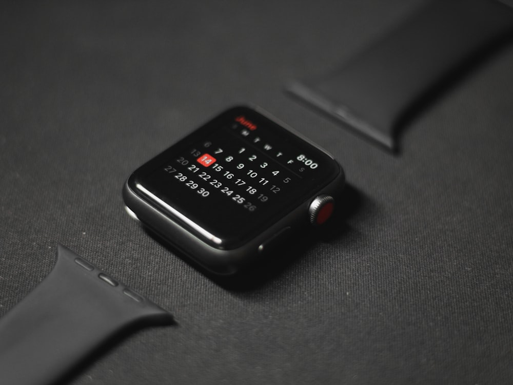 black smart watch on black surface