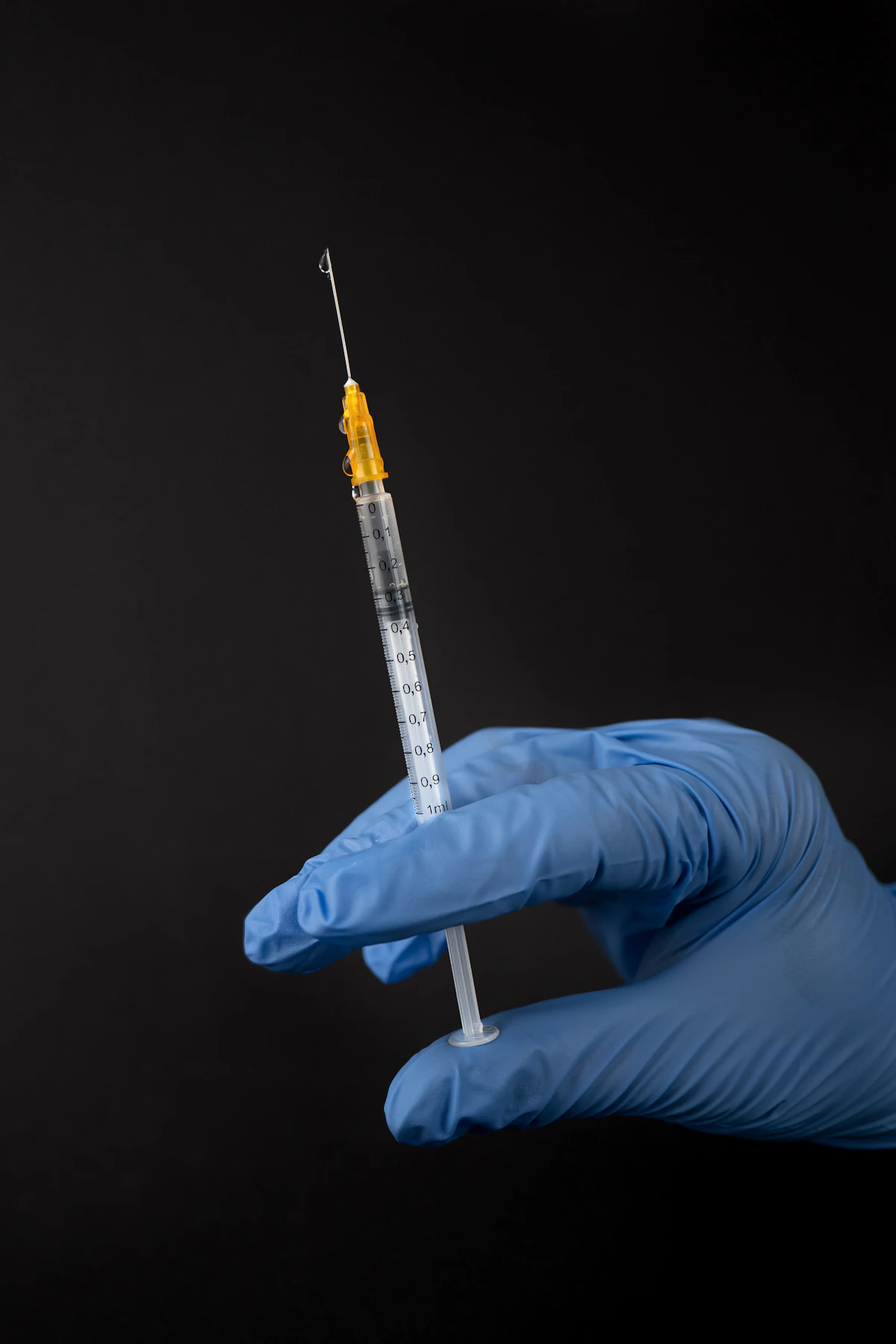 Sterile syringe in blue-gloved hands, the injectable BPC-157 route studied for tendon and muscle endpoints in rodent models