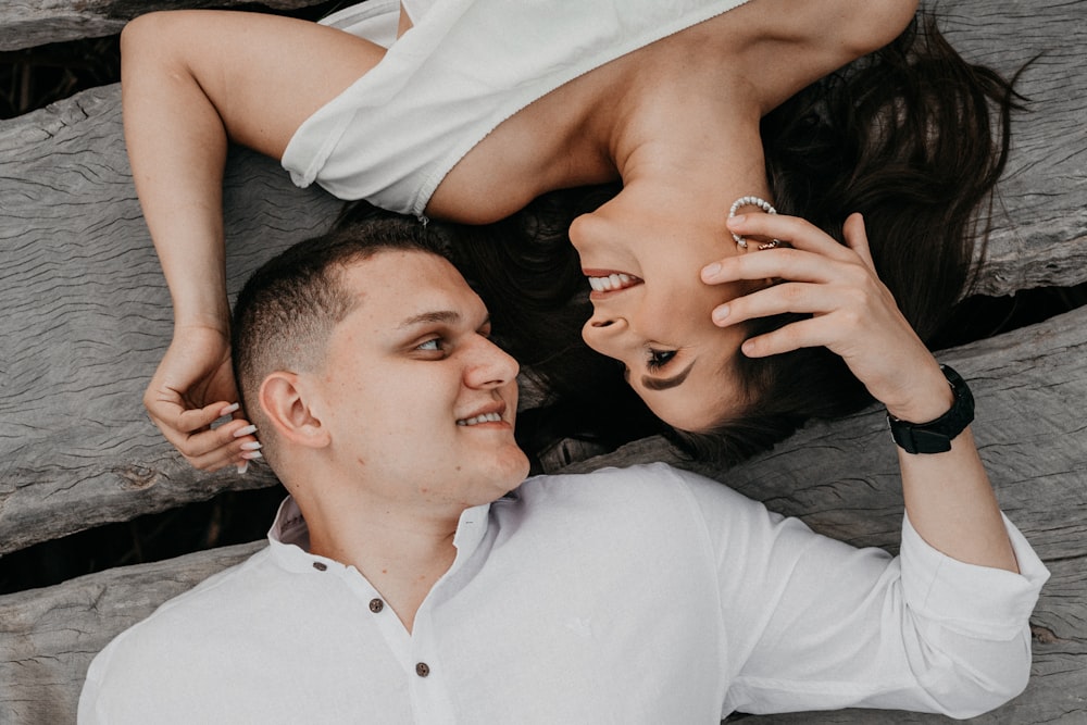 man in white polo shirt kissing woman in black tank top