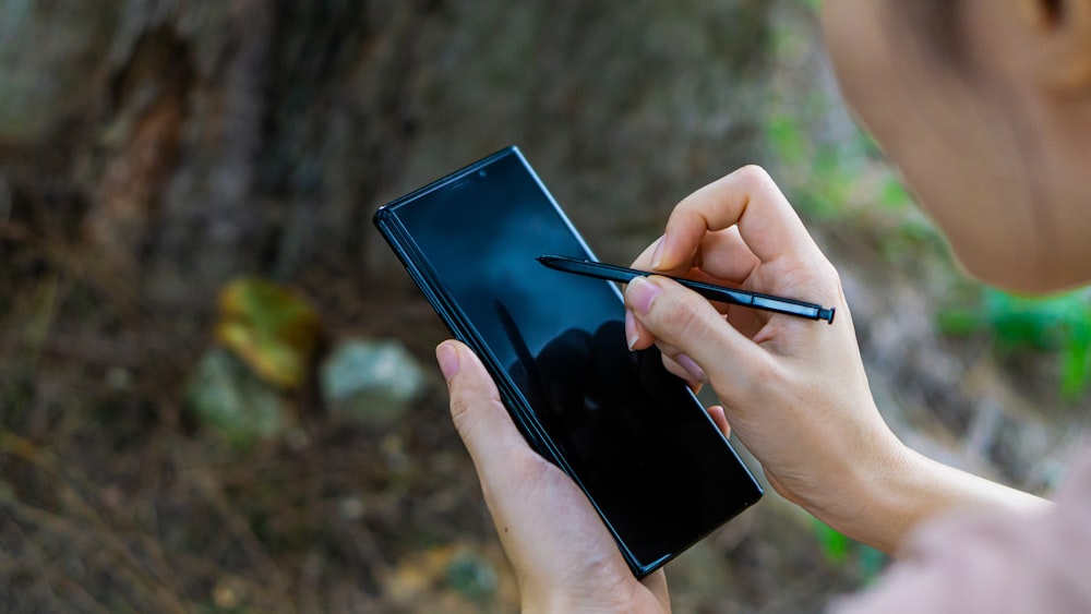 person holding black tablet computer