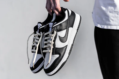 Hands holding a pair of fresh, clean stridevibe sneakers against a bright backdrop.