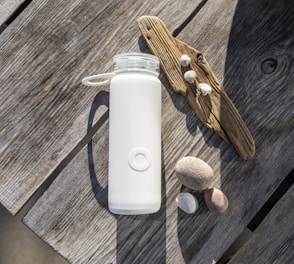 white apple remote beside brown wooden handle knife and white plastic bottle