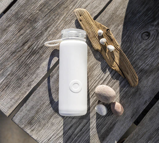 Close-up of the 7-liter Terramar hydration bottle resting on a sunlit wooden table by the sea.
