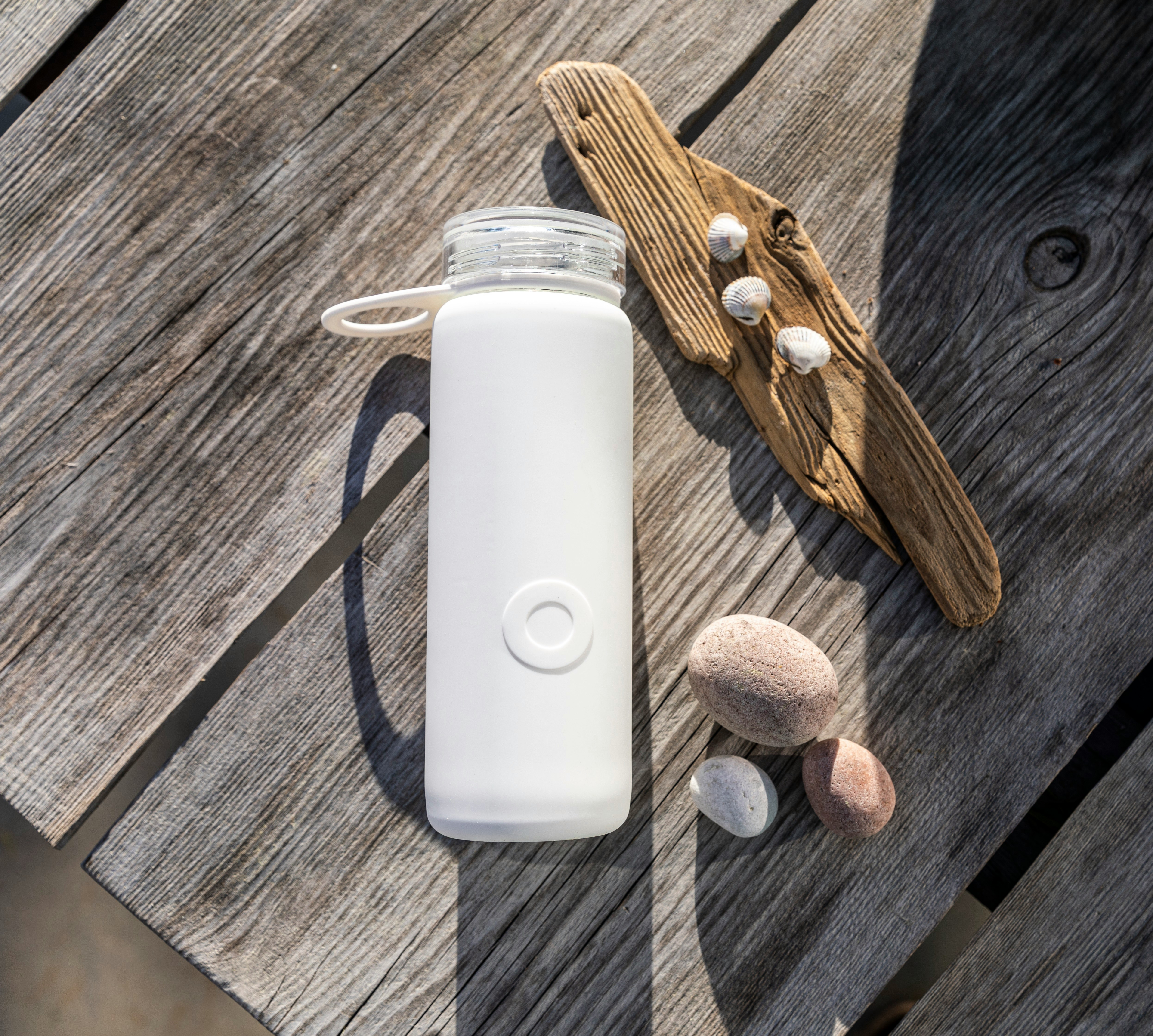 white apple remote beside brown wooden handle knife and white plastic bottle