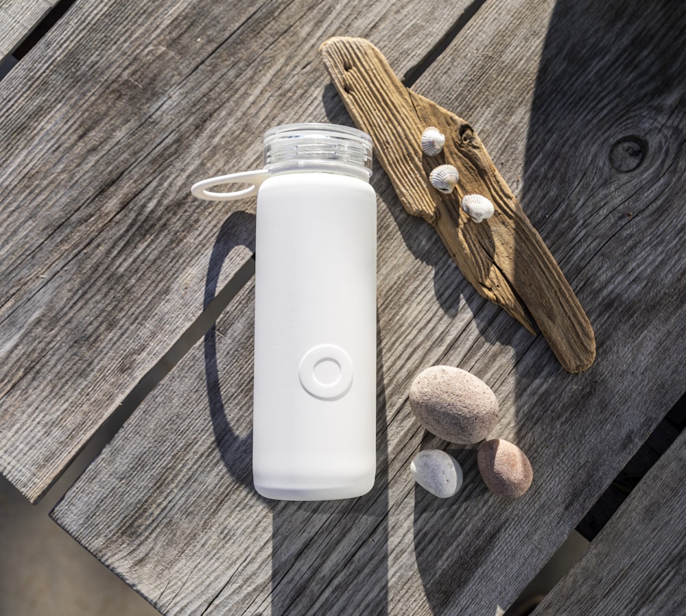 white apple remote beside brown wooden handle knife and white plastic bottle