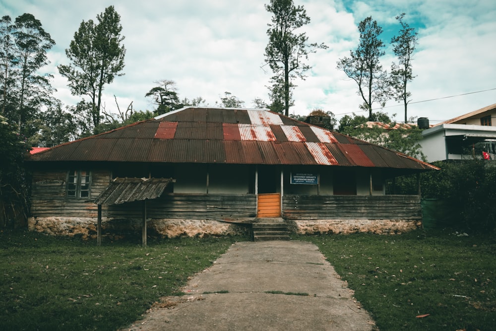 brown wooden house near green trees during daytime