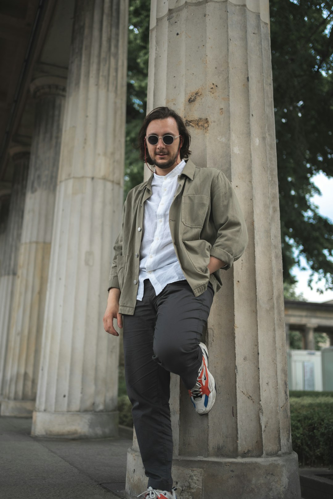 man in gray coat standing beside brown concrete wall during daytime