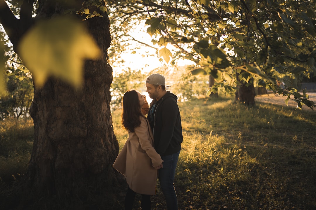 man and woman standing under tree during daytime