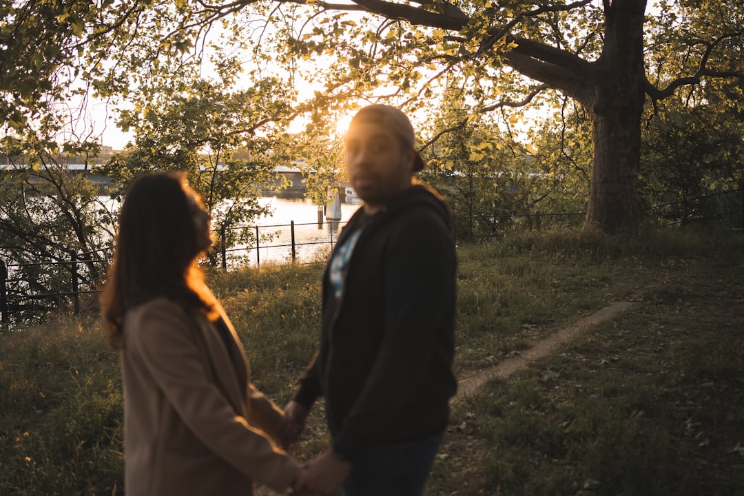 man in black jacket standing beside woman in white coat