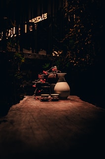 A rustic wooden table set with various traditional meads and ales surrounded by natural scenery.