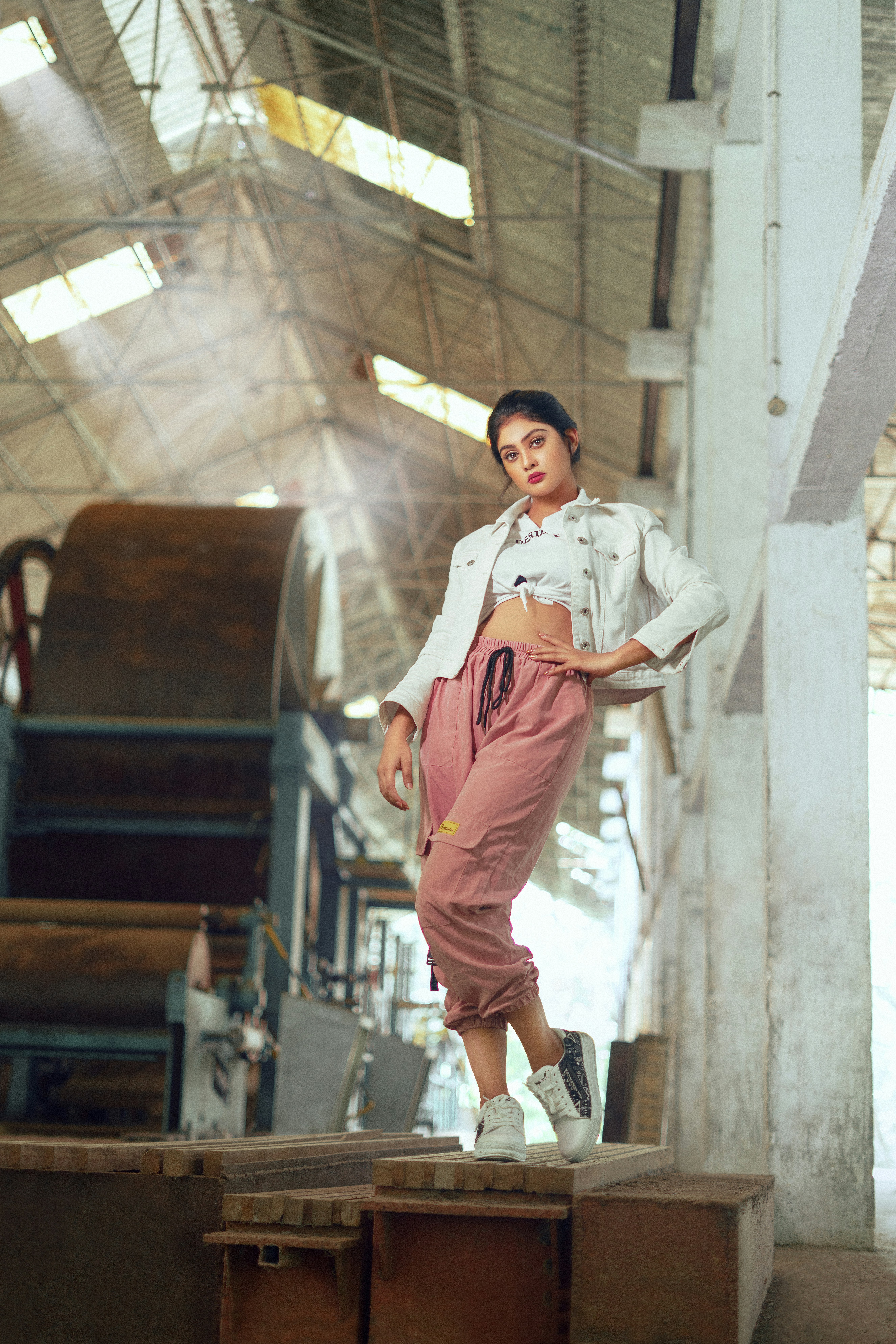 woman in white button up shirt and brown pants standing on stairs