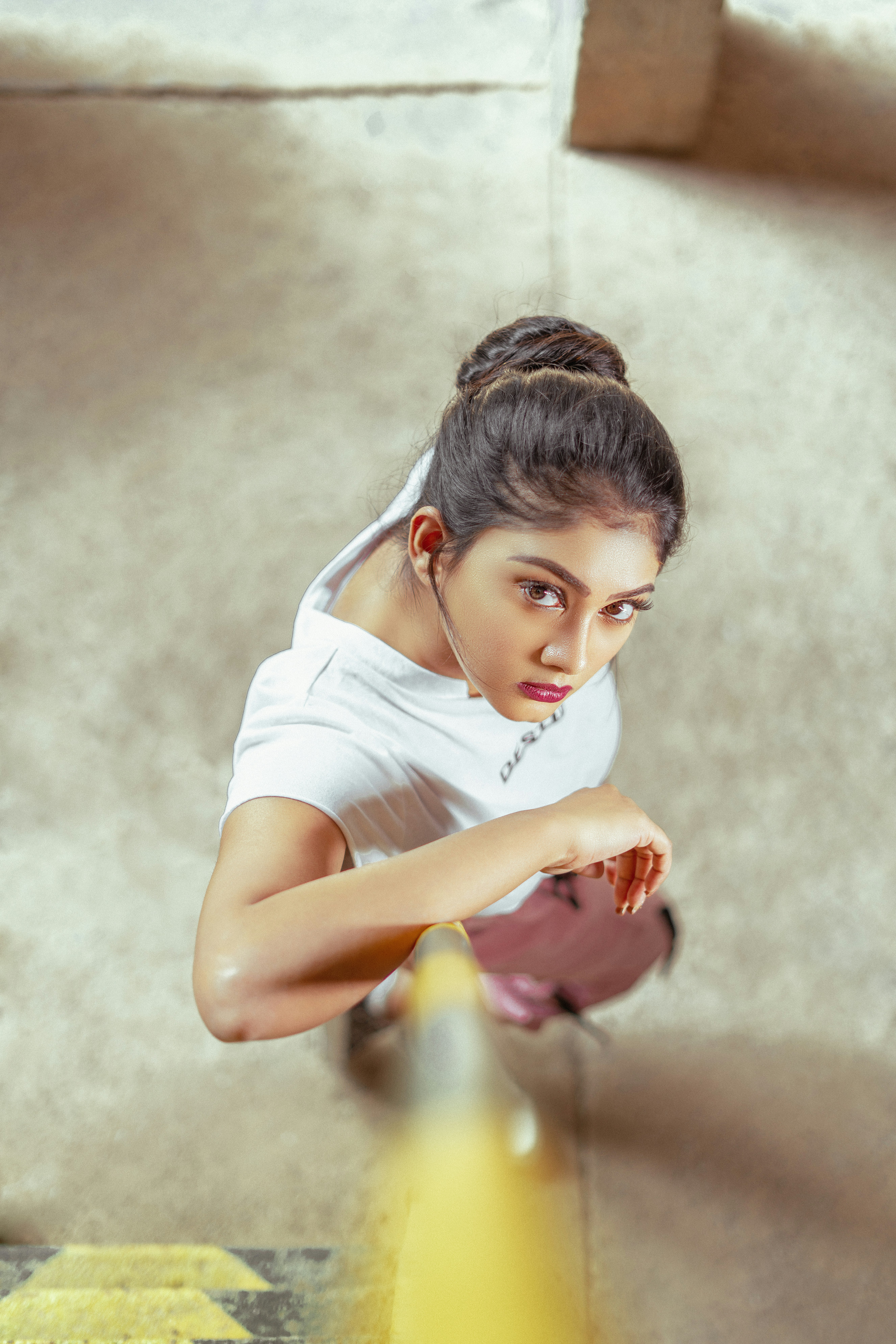 A girl in a white t-shirt and white pants sitting on the floor