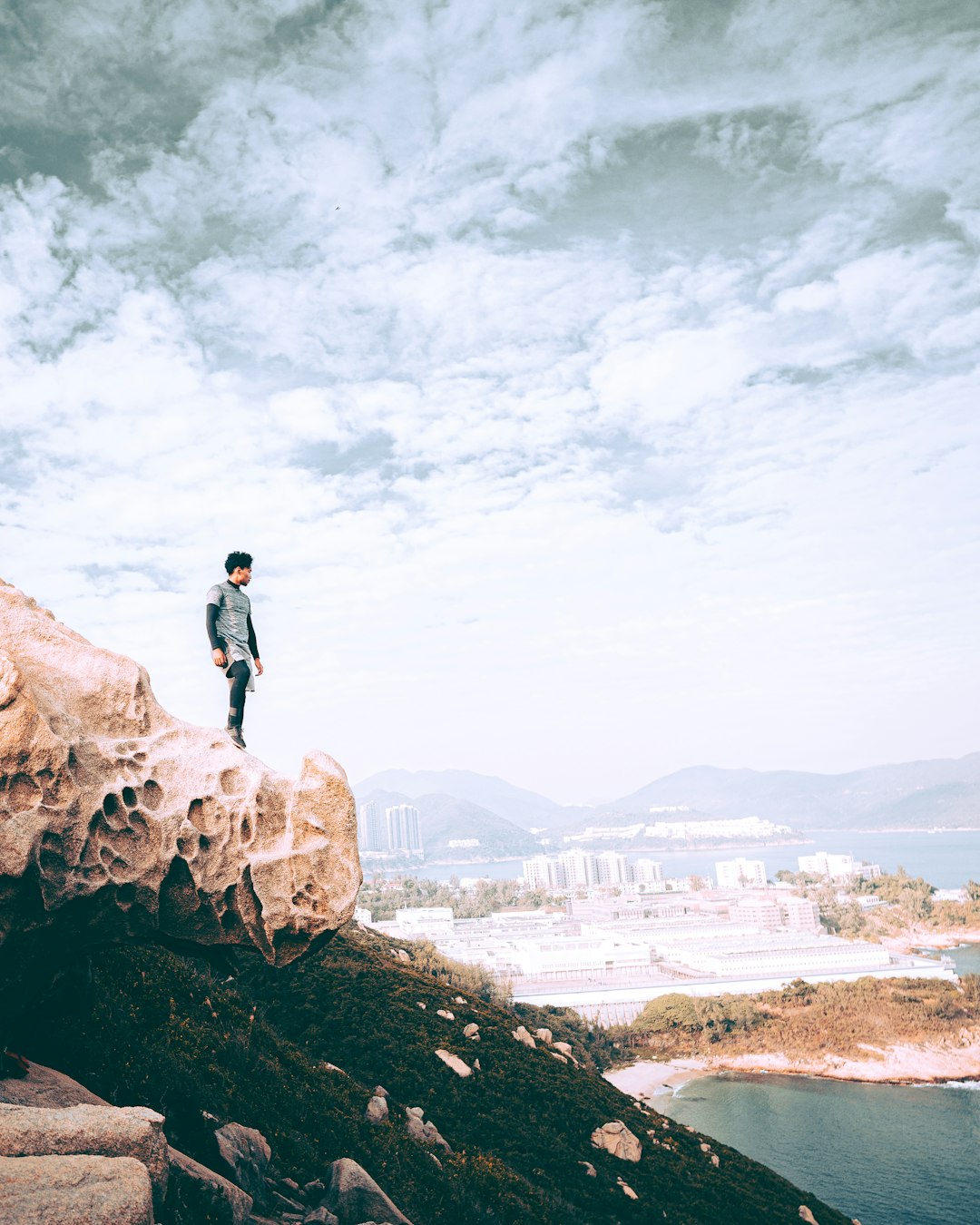 man in black jacket standing on brown rock formation during daytime