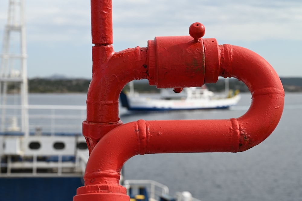 Garde-corps en métal rouge près d’un plan d’eau pendant la journée