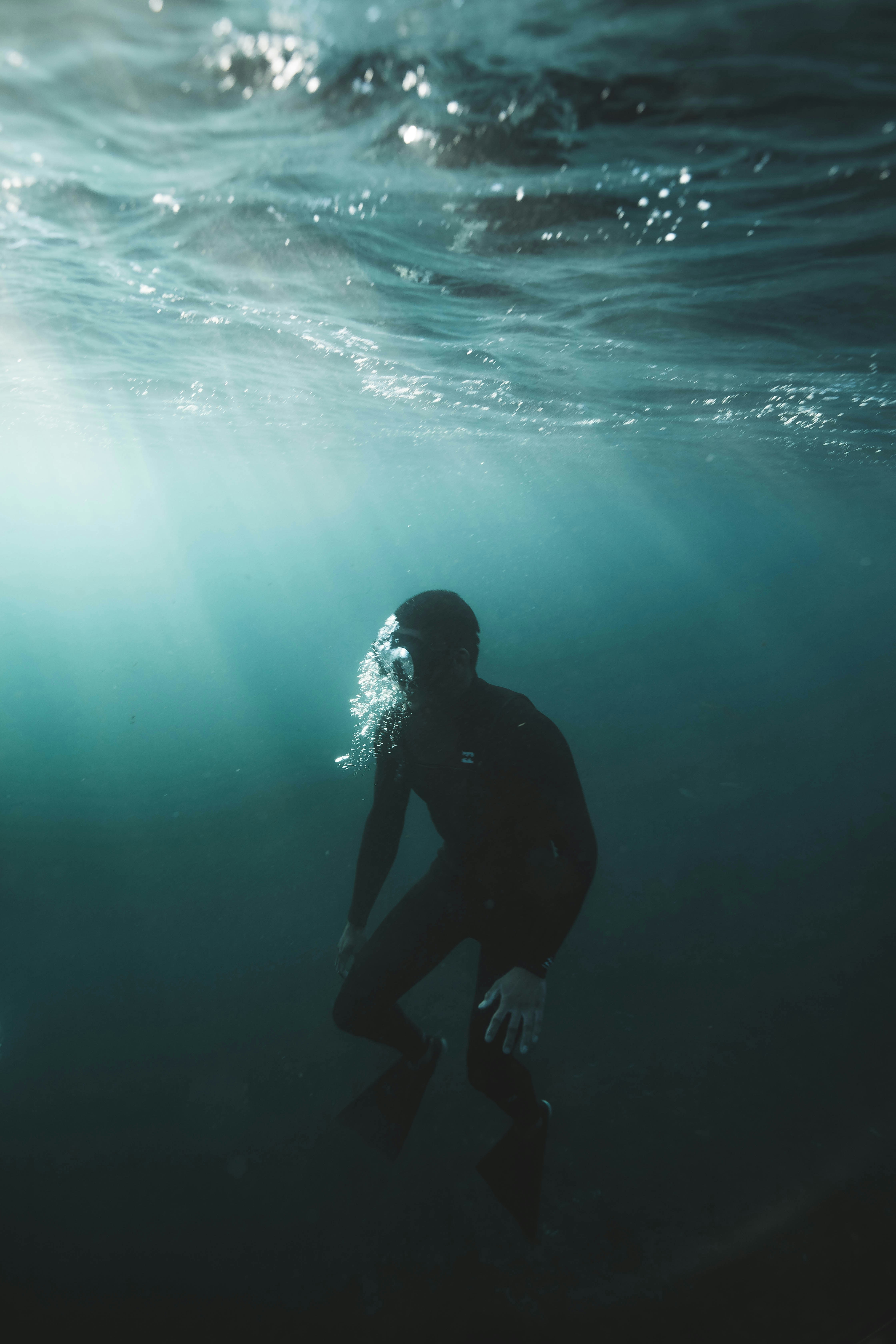 man in black wet suit in water