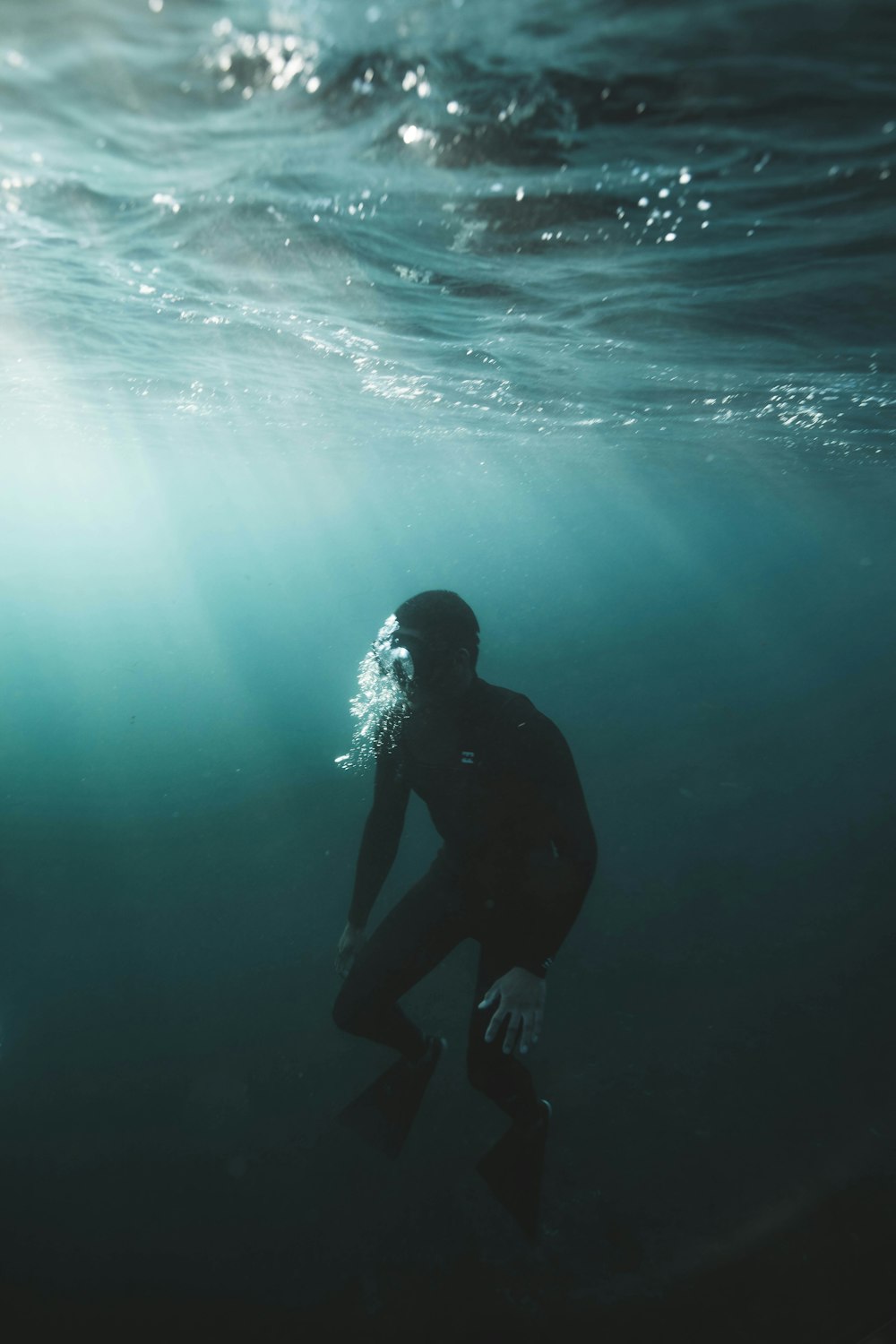 man in black wet suit in water