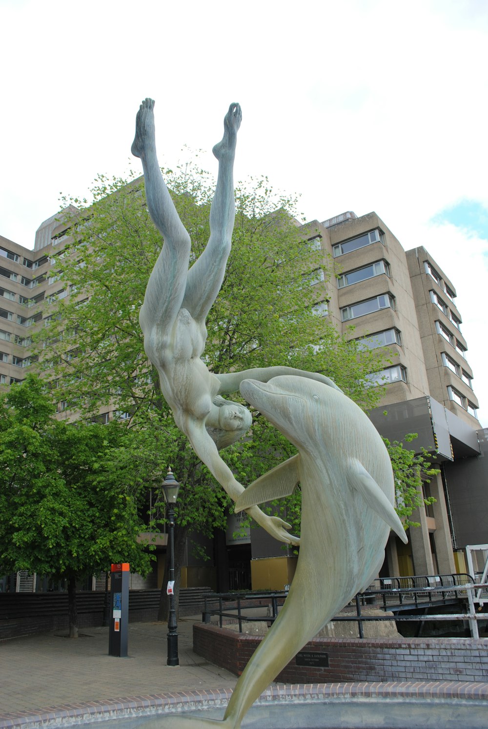 Estatua de hormigón blanco cerca de un edificio de hormigón marrón durante el día