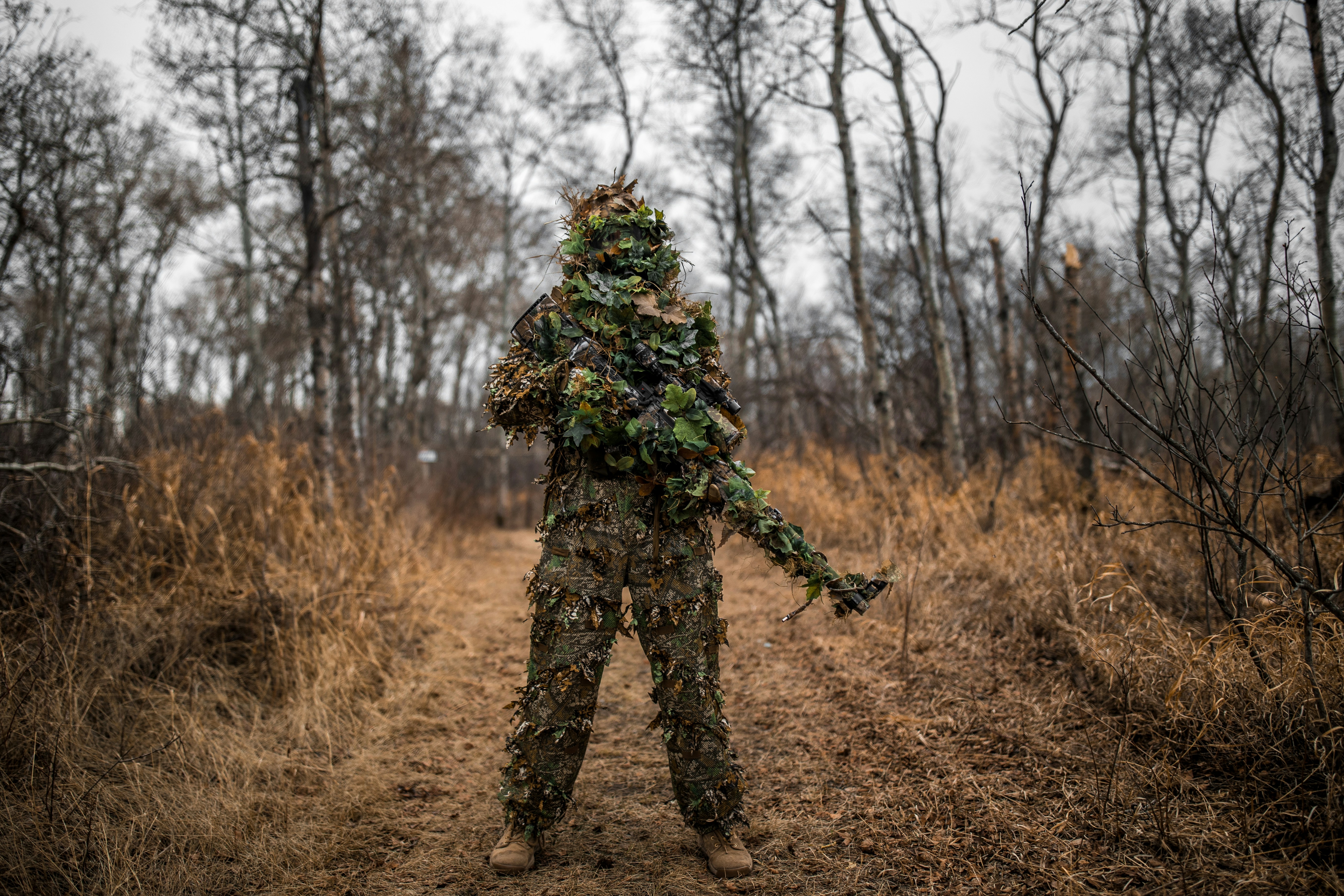 Ghillie sniper in a Novritsch ghillie suit holding a Novritsch SSG96 airsoft sniper Model: @Airsoft_Stinii (Instagram)