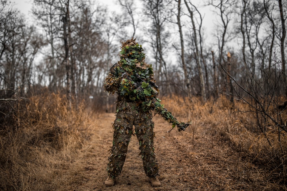 man in green and black camouflage jacket standing on brown grass field during daytime