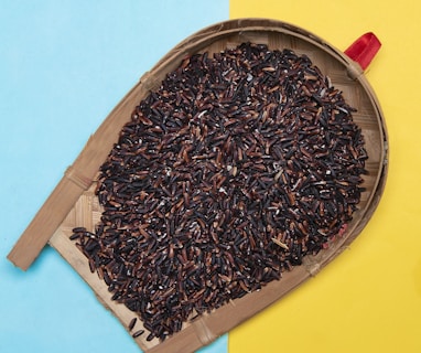 black and brown round seeds on brown wooden tray