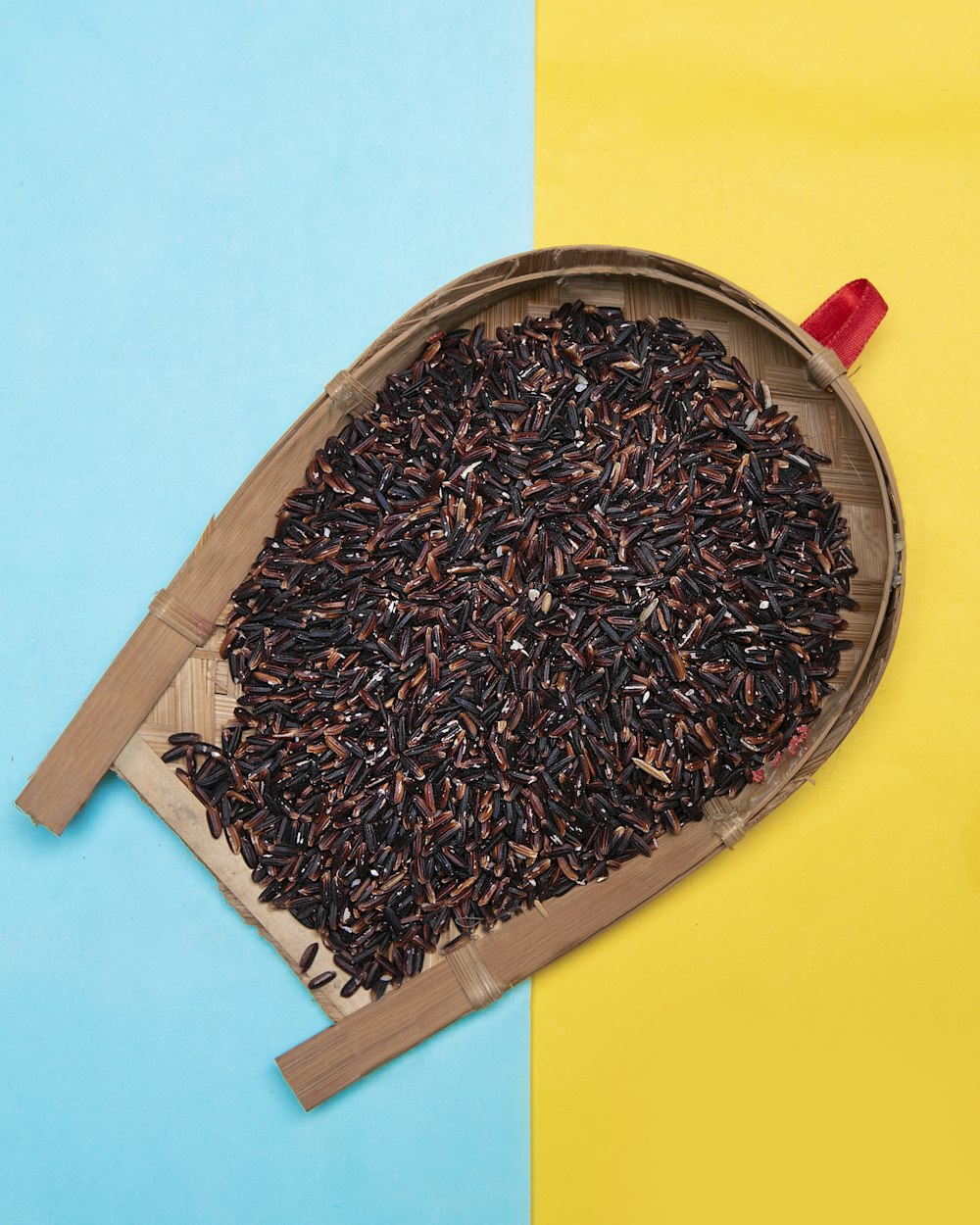 black and brown round seeds on brown wooden tray