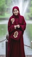 woman in red hijab standing near body of water during daytime