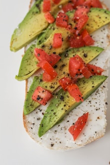sliced tomato and green vegetable on white ceramic plate