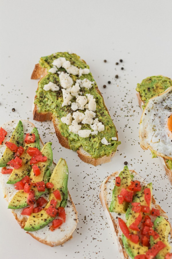 Green and brown bread with sliced tomato and green vegetable on white ceramic plate