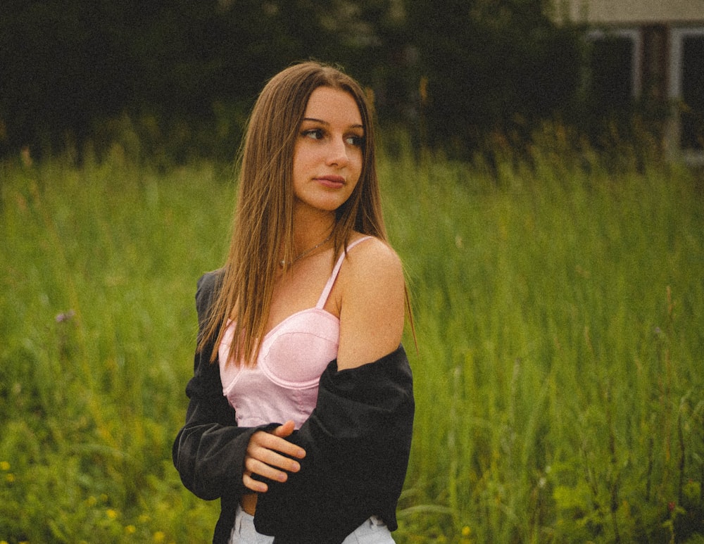 woman in black and white long sleeve shirt standing on green grass field during daytime