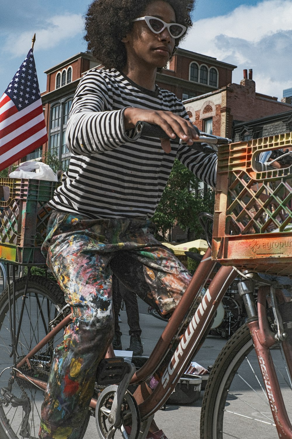 femme en chemise rayée noire et blanche et pantalon gris équipant sur le vélo