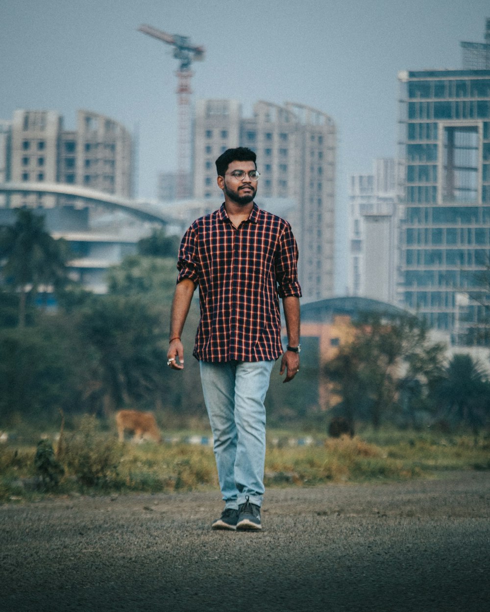 man in red and black checkered dress shirt standing on brown field during daytime