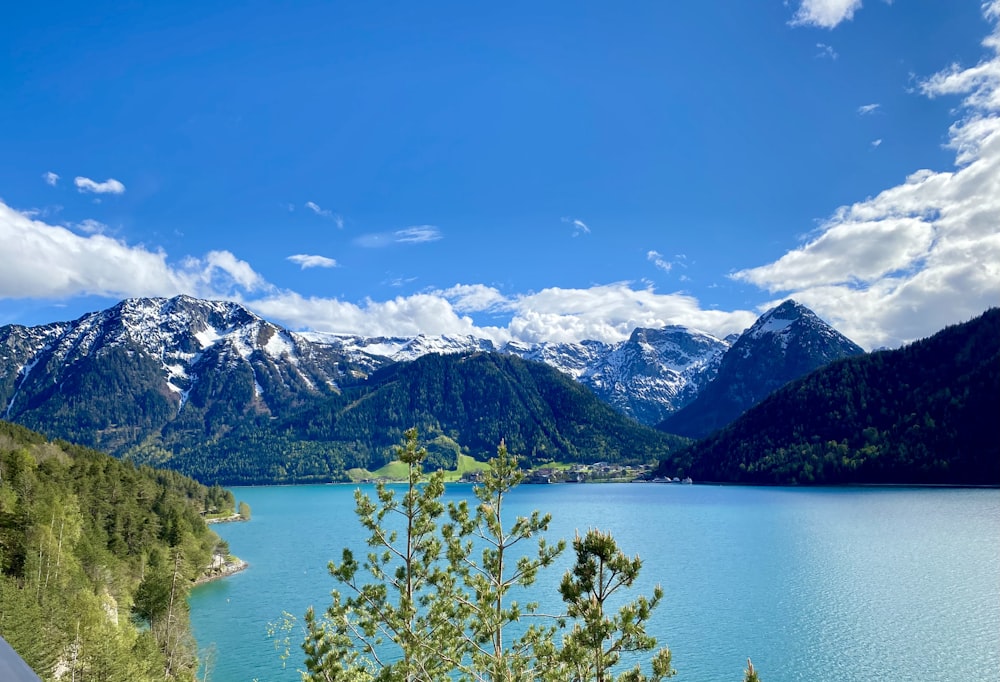 green mountains near body of water under blue sky during daytime