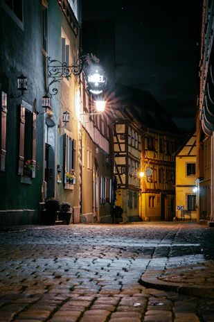 Cozy boutique hotel room featuring rustic decor and a view of cobblestone streets.