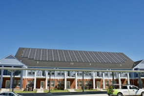 Commercial building with large solar panel arrays reflecting sunlight.