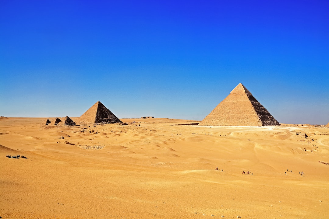 brown pyramid on desert under blue sky during daytime