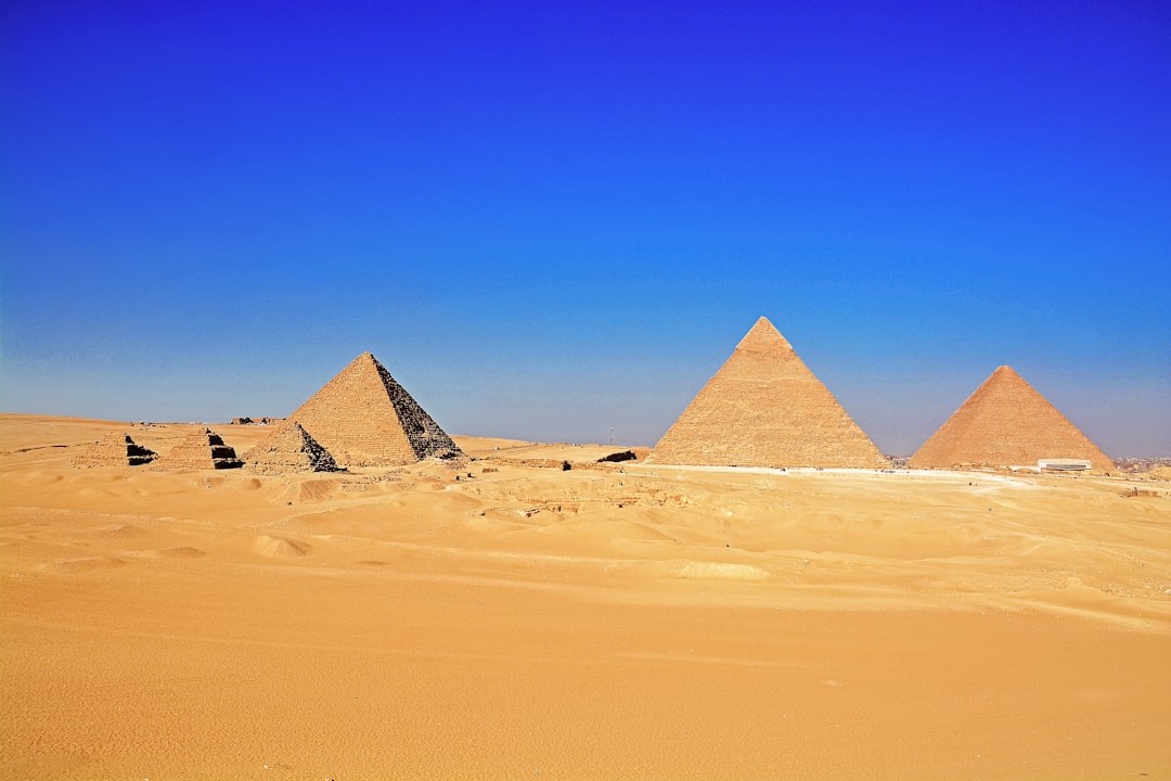 brown pyramid on desert under blue sky during daytime