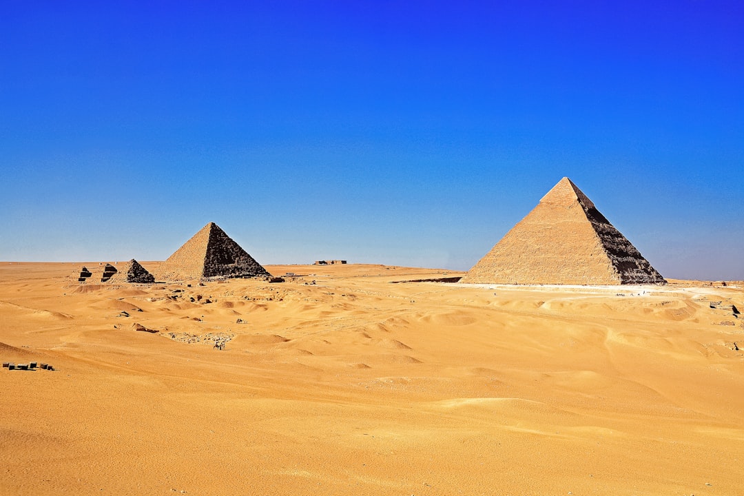 brown pyramid on desert under blue sky during daytime