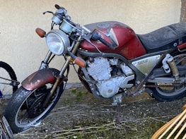 Vintage motorcycle with missing plastic parts highlighted.