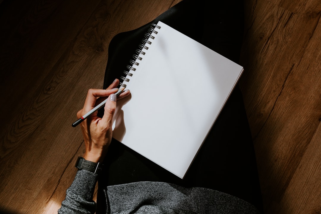  person writing on white paper sheet