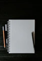 white spiral notebook beside orange pen