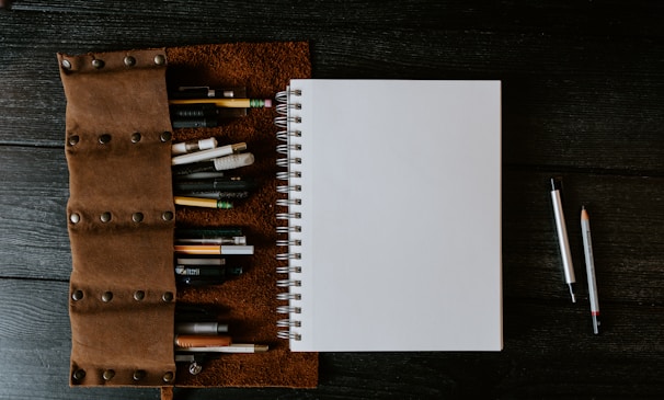 white spiral notebook on brown wooden table