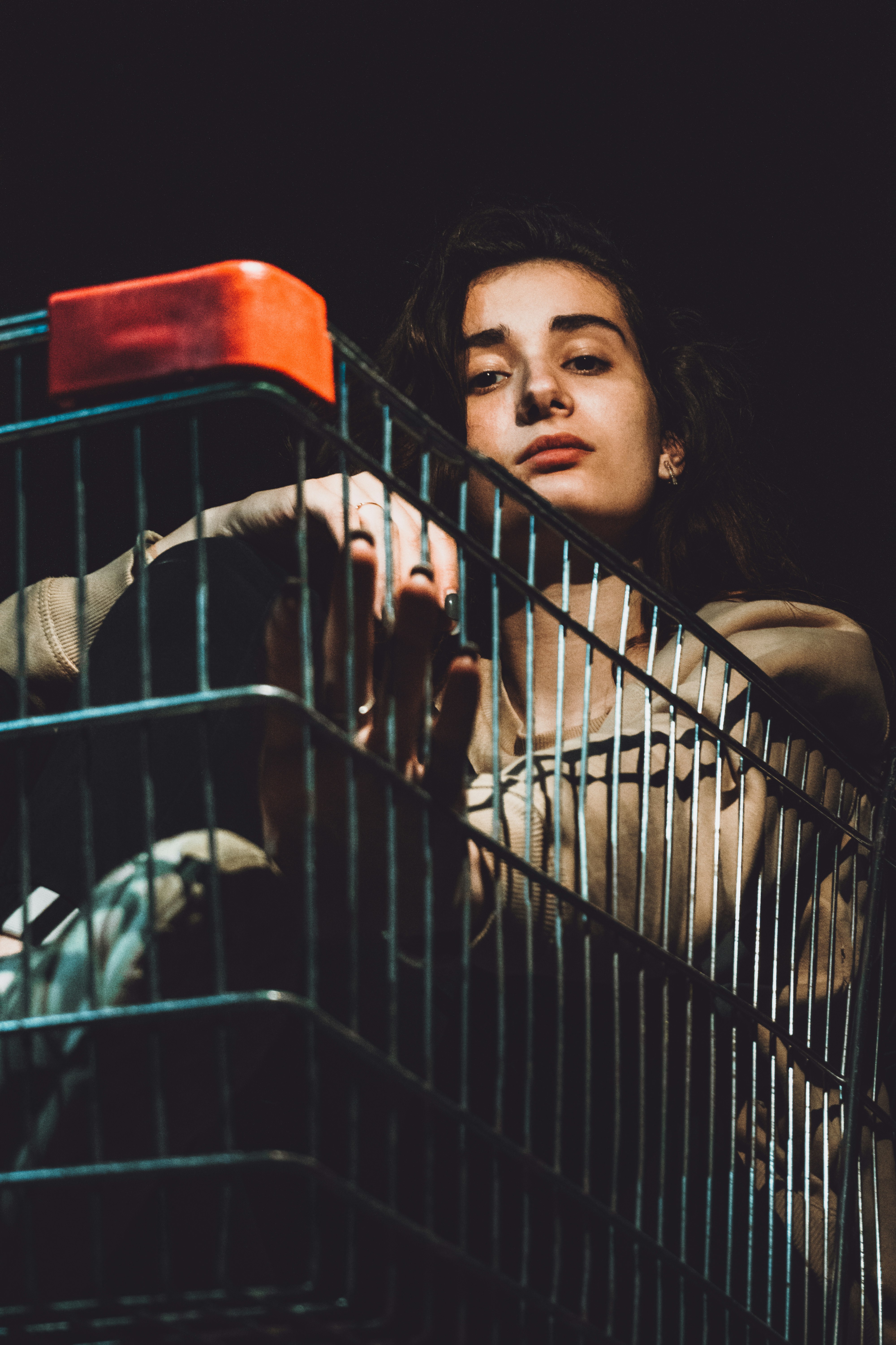 woman in black tank top sitting on white metal pet cage