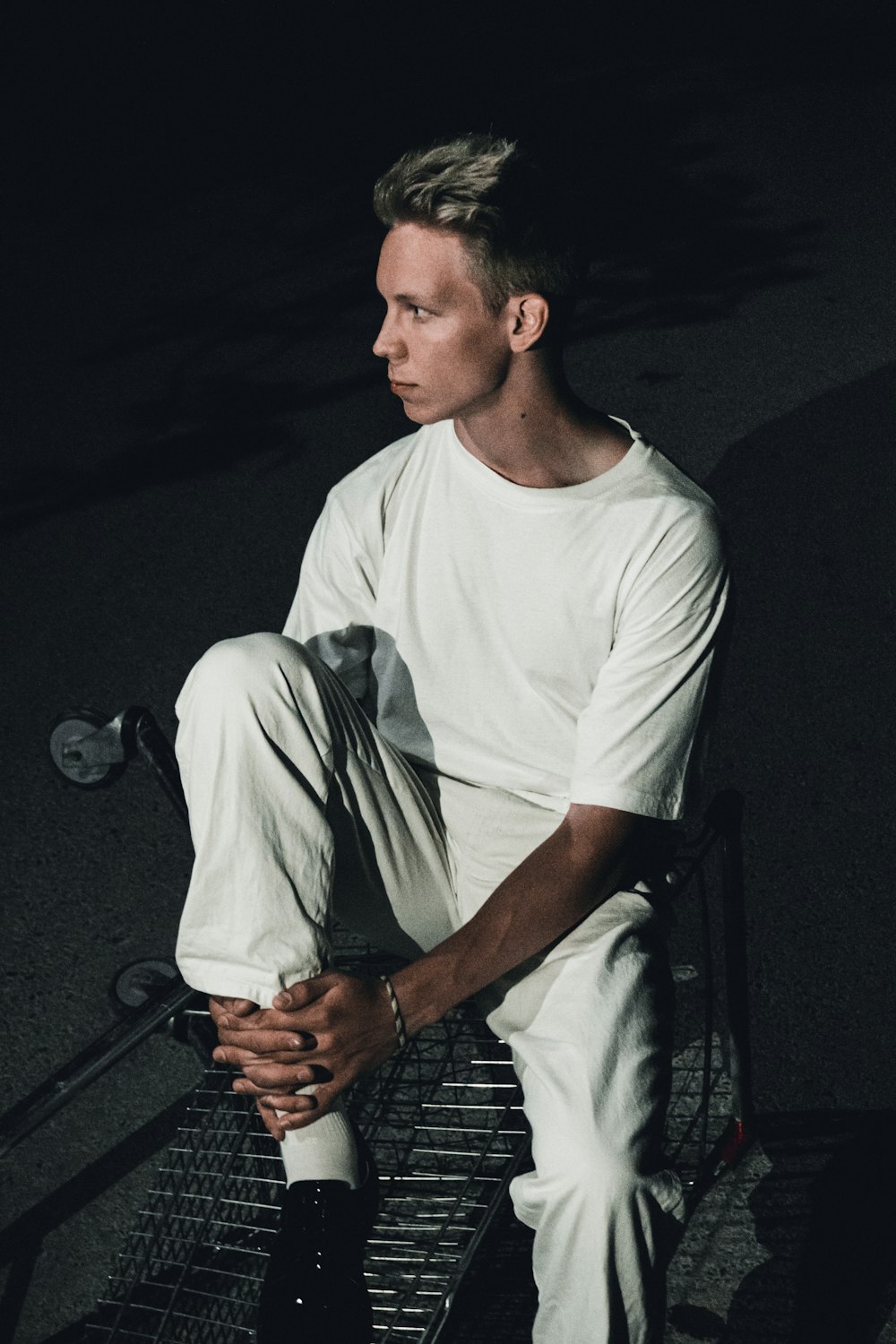man in white crew neck t-shirt sitting on black steel chair